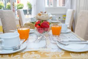 威尼斯卡萨皮特罗卡酒店的一张桌子,早餐包括橙汁和草莓