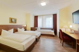 杜塞尔多夫杜塞尔多夫舒马赫尔酒店的酒店客房配有两张床和一张书桌
