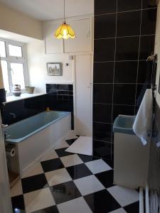 香农河畔卡里克Bridge House的带浴缸的浴室以及黑白格子地板。