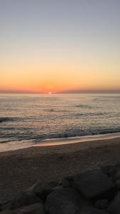波瓦-迪瓦尔津Casa na Praia的日落在海滩上与大海