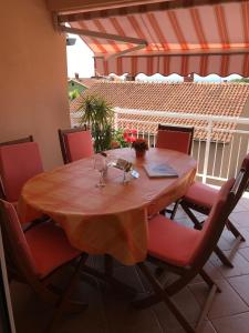 波雷奇马里奇房屋酒店的一张带红椅子的木桌和一张带酒杯的桌子