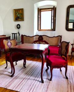 蒂豪尼The Houses of History - anno 1830的客厅配有木桌和椅子