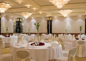 麦纳麦喜来登巴林酒店的宴会厅配有白色的桌椅和吊灯