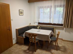 拉纳Ferienwohnung Winklerhof的一间带桌椅和窗户的用餐室