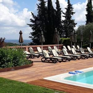 蒙特卡洛La Torre wine resort的一组椅子和遮阳伞,位于游泳池旁