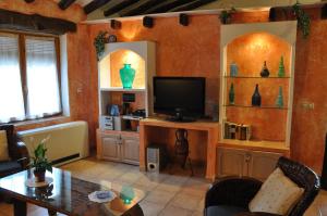 莱图尔Casa Rural El Pajar del Portalico的客厅配有电视和桌椅