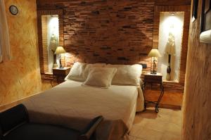 莱图尔Casa Rural El Pajar del Portalico的一间卧室配有一张砖墙床