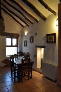 莱图尔Casa Rural El Pajar del Portalico的一间带桌椅和壁炉的用餐室