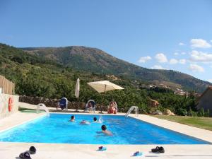 Casas del MonteApartamentos rurales Manolo的一群人在游泳池里