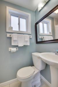 大洋城白马林宾馆的一间带卫生间、水槽和镜子的浴室