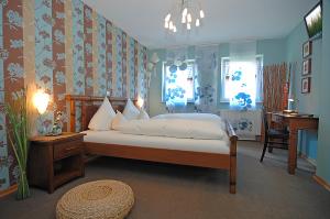 温德哈根风之4号餐厅酒店的卧室配有一张床、一张书桌和窗户。