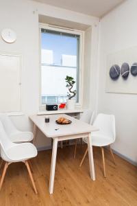 赫尔辛基Orchidea Kamppi的白色的用餐室配有桌子和白色的椅子