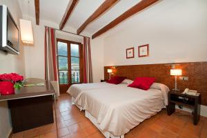 德阿Hotel y Apartamentos DES PUIG的卧室配有带红色枕头的大型白色床