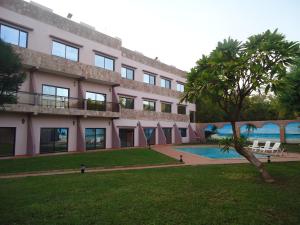 巴马科Le Relais de Bamako的一座带游泳池和棕榈树的建筑