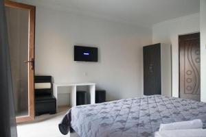 巴统伊比利亚酒店的卧室配有一张床,墙上配有电视