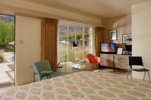 棕榈泉The Hideaway的一间卧室配有一张床、椅子和电视