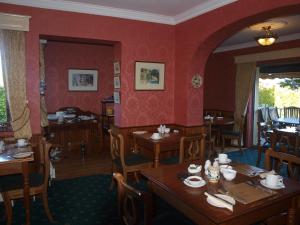 阿斯隆Shelmalier House的用餐室设有木桌和红色墙壁