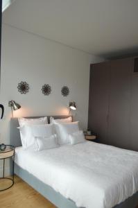 波尔图Camões by Trindade Sweet Home的一间卧室配有一张带两盏灯的大型白色床。
