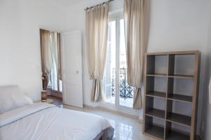 马赛Place au Manege的一间卧室设有一张床和一个阳台的窗户。