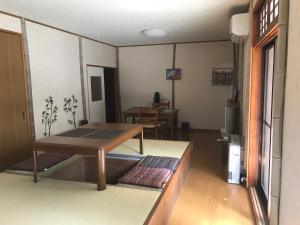 高山Takayama Ninja House的一间带桌子的客厅和一间餐厅