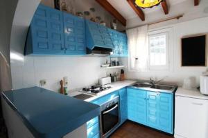 莫莱拉Casa Ian的蓝色的厨房,配有白色的柜台和蓝色的橱柜