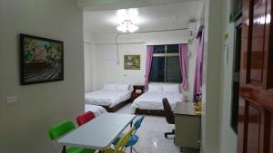 Minxiong旺来庭园民宿的一间设有两张床和一张桌子及椅子的房间