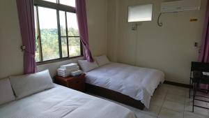 Minxiong旺来庭园民宿的带窗户的客房内的两张床