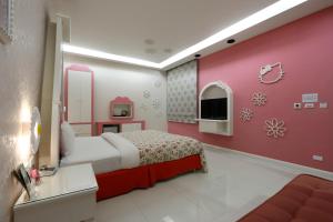 Qishan花乡旅馆连锁-旗山店的一间卧室配有一张床和粉红色的墙壁