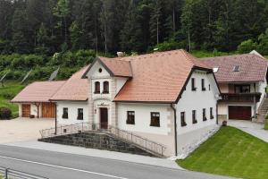 LjubnoFarm stay Bukovje的路边有红色屋顶的白色房子
