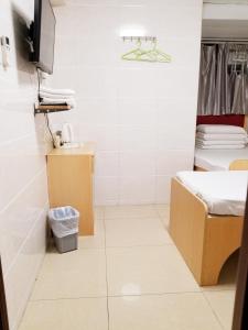 香港亚洲旅游宾馆的一间带床和卫生间的小浴室