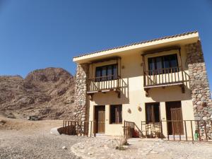 圣凯瑟琳圣凯瑟琳丹妮拉村庄酒店的沙漠中的一座建筑,以群山为背景