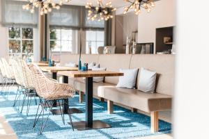 圣彼得奥尔丁杜塞尔多夫兰德豪斯酒店的蓝色地毯上的带桌椅的用餐室