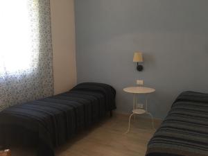 马尔扎梅米弗特村酒店的客房设有两张床、一张桌子和一扇窗户。