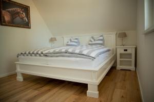博恩Grüne Hufe的白色的床和蓝色的白色枕头
