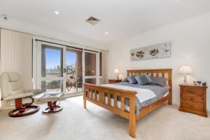阿德莱德Adelaide Style Accommodation-Close to City-North Adelaide-3 Bdrm-free Parking的卧室配有床、椅子和窗户。