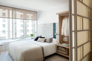 汉堡埃里克沃克尔精品公寓 - 汉堡套房的卧室设有白色的床和大窗户