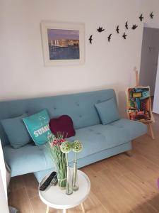 比奥格勒·纳·莫鲁Guest house DIA - Details make a diference的客厅配有蓝色的沙发和带鲜花的桌子