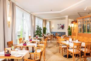 格洛韦格洛威贝尔艾尔斯特拉兰德酒店的餐厅设有木桌、椅子和窗户。