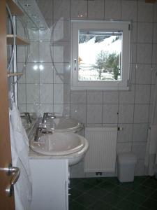 大格洛克纳山麓卡尔斯Haus Gartenheim的一间带两个盥洗盆和窗户的浴室