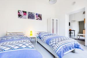 门兴格拉德巴赫Apartments Mönchengladbach的白色客房的两张床,配有蓝色和白色的床单