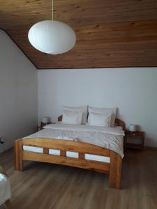 Zakroczym奥萨莫德林机场乡村民宿的一间卧室设有一张带木制天花板的大床