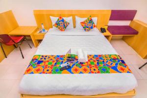 钦奈FabExpress Picnic Plaza Mylapore的一间卧室配有一张大床和彩色床罩