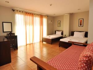 塔比拉兰海港花园旅游宾馆的一间卧室设有两张床和大窗户