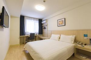 黄山市锦江之星风尚黄山火车站老街酒店的酒店客房配有一张床、一张书桌和一台电视。