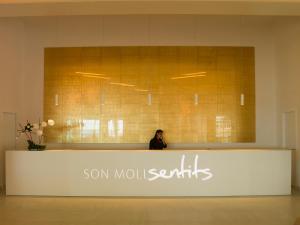 卡拉纳雅达Son Moll Sentits Hotel & Spa的站在大厅柜台后面的女人
