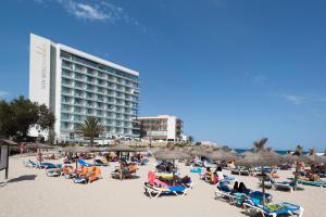 卡拉纳雅达Son Moll Sentits Hotel & Spa的一个带椅子和遮阳伞的海滩和一家酒店