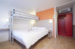 沙斯讷伊迪普瓦图沙斯讷伊未来世界普瑞米尔经典酒店的一间卧室配有一张床和一张双层床。