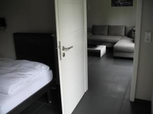 阿德瑙环山路公寓式酒店的通往卧室的开放式门,卧室配有床和沙发