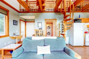 奥福德港Whimsy by the Sea的客厅设有蓝色的沙发和楼梯。