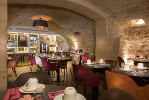 巴黎杜卡德安酒店的一间带桌椅的餐厅和一间酒吧
